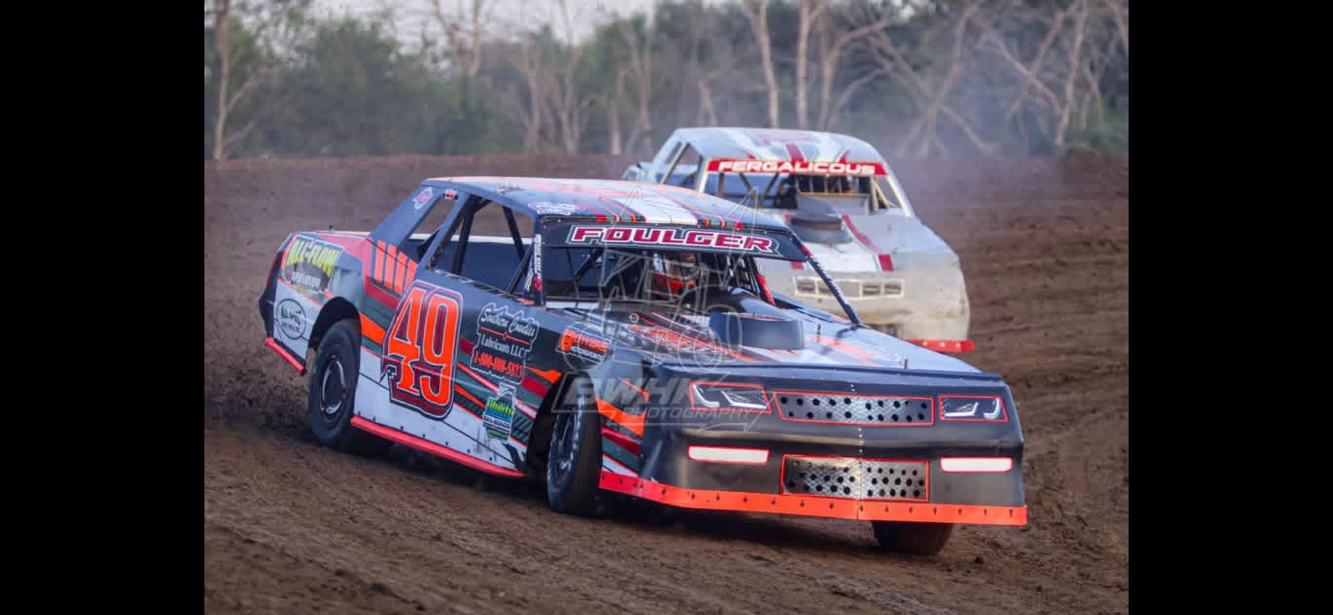 No. 49 car cornering hard on the dirt, close on the FOULGER lettering