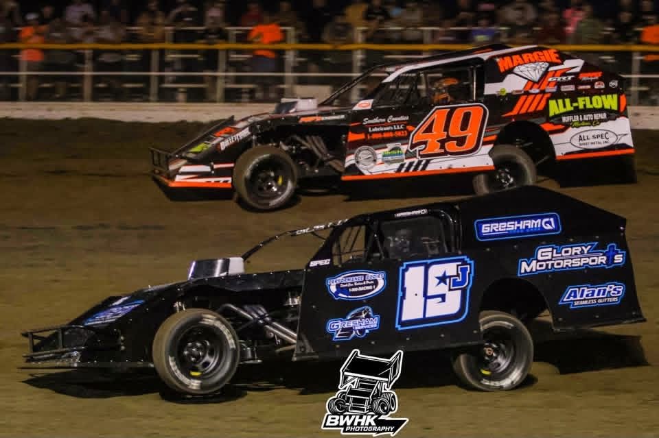 No. 49 racing alongside another car in front of the grandstands