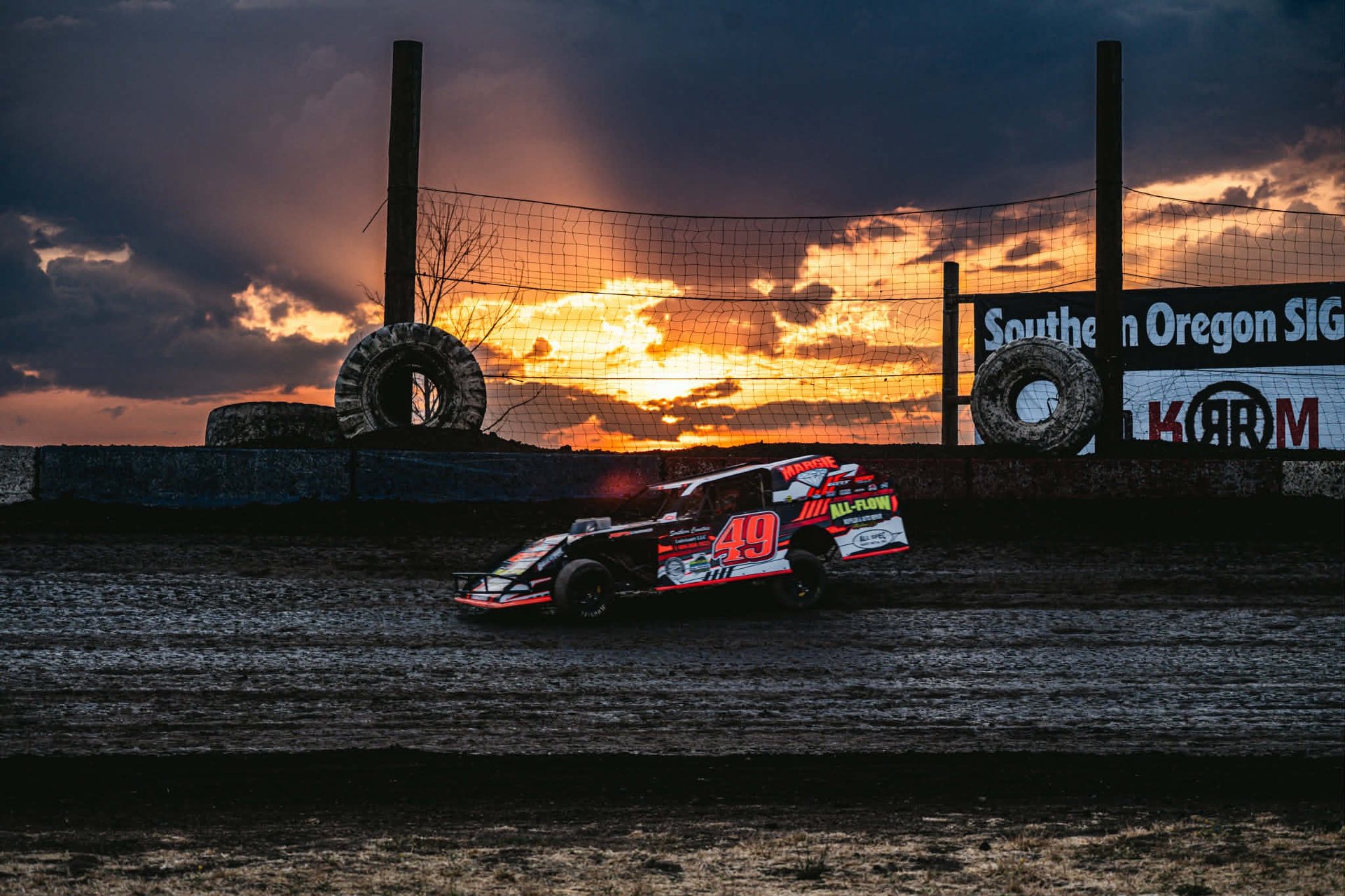 No. 49 car parked on track at sunset near the tire barrier